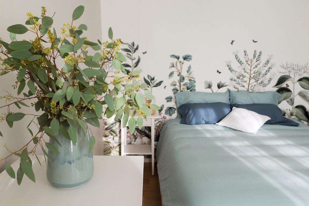 Chambre lumineuse aux tons doux et bouquet de feuillage